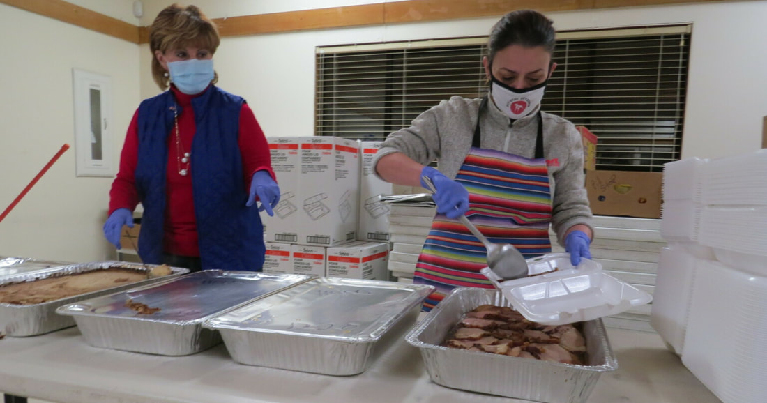 Volunteers with PitStop Outreach prepare food boxes for delivery.
