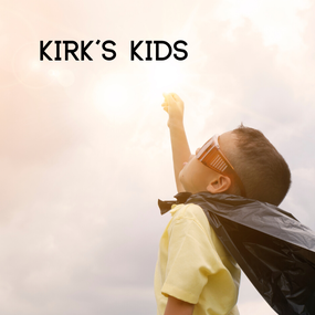 Little boy in a super hero cape raising a hand toward the sun